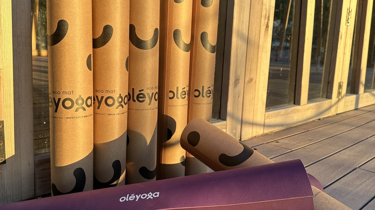 Rolled purple oléyoga yoga mats and their cardboard tubes ready at the event venue