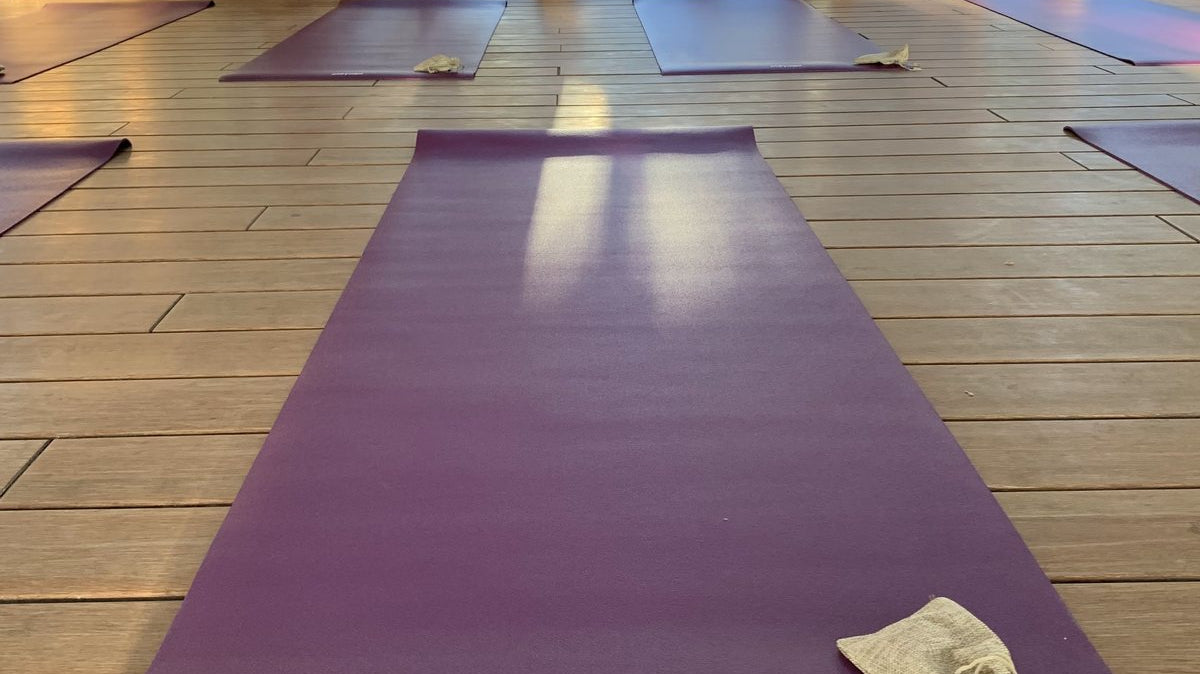 Purple oléyoga yoga mats arranged for an event in a wooden pavilion at Casa Kavi