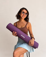 Modelo con esterilla Deep Purple enrollada oléyoga