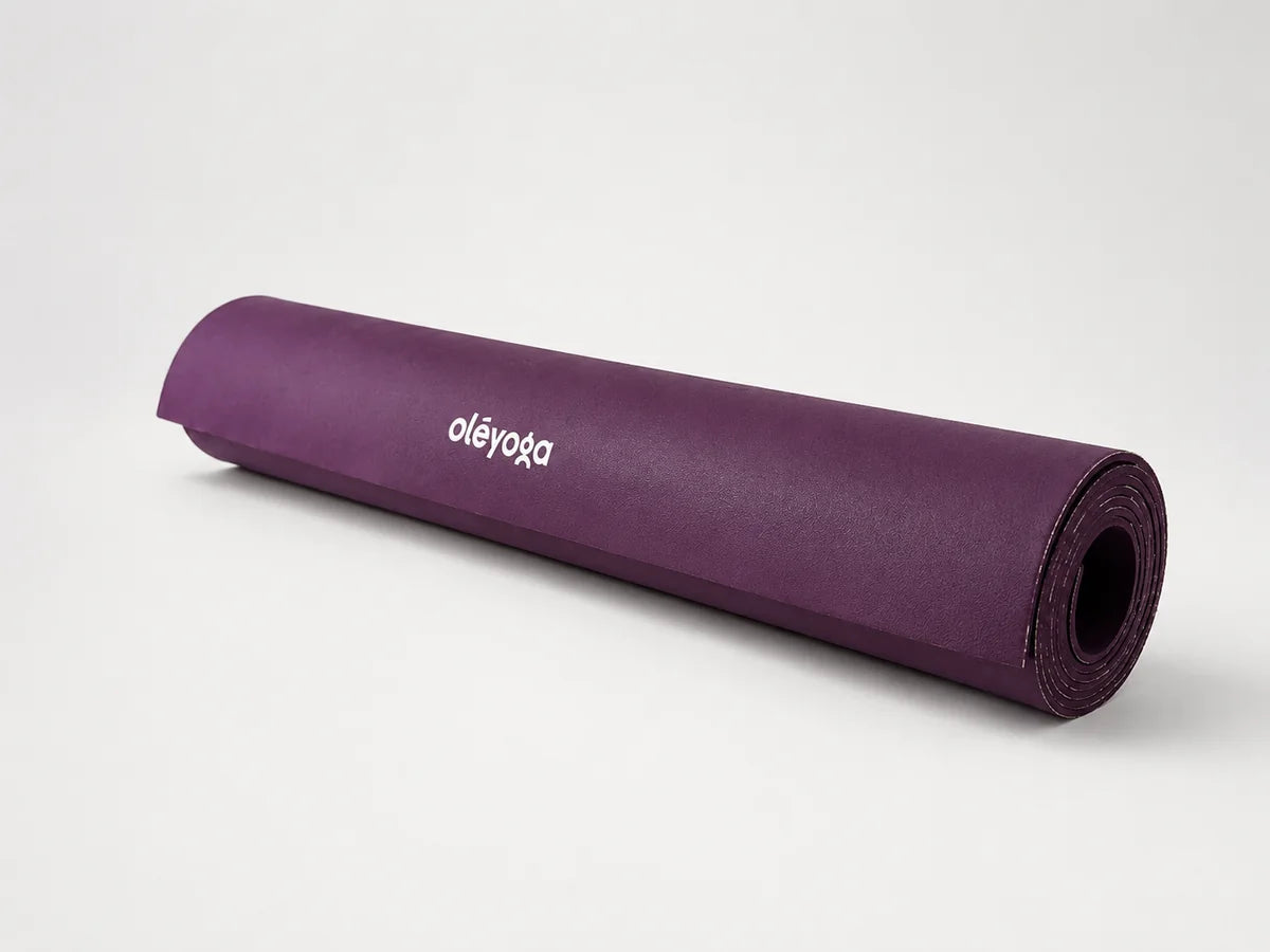Rolled Eco Daily Deep Purple yoga mat on a light background.