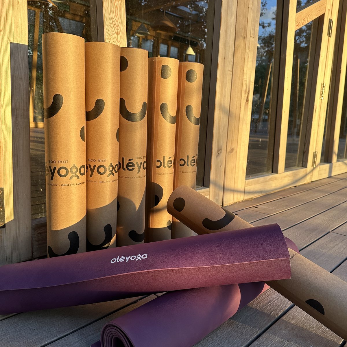 Rolled purple oléyoga yoga mats and their cardboard tubes ready at the event venue