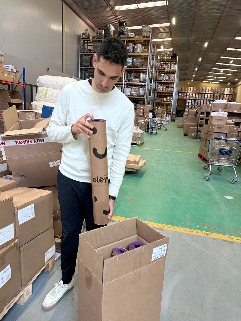 David checking oléyoga mat packaging in the warehouse.