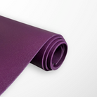 Deep Purple Eco Daily yoga mat rolled up, showing its 4 mm thickness