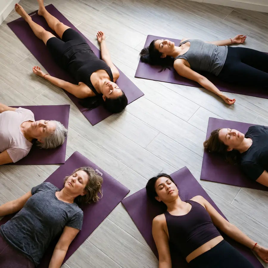 Overhead view of a group lying in savasana on their mats