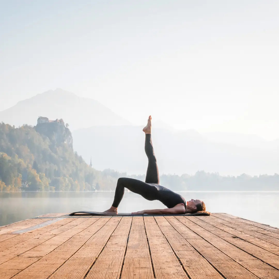 Rolled oléyoga yoga mat standing against a tree